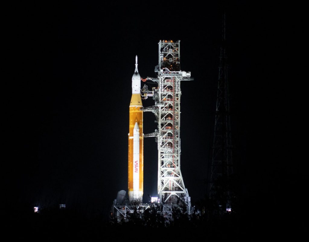 NASA’s Space Launch System (SLS) rocket with the Orion spacecraft aboard is seen illuminated by spotlights atop a mobile launcher at Launch Complex 39B, Friday, March 18, 2022, after being rollout out to the launch pad for the first time at NASA’s Kennedy Space Center in Florida. Photo Credit: (NASA/Joel Kowsky)